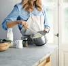A person is whisking ingredients in a bowl on a kitchen counter. Produktbild-Vorschau