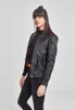 A woman is posing in a studio setting wearing a black bomber jacket. Produktbild-Vorschau