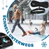 A man pulling a child on a sled through a snowy forest, with a deer in the background. A close-up of a rope and handle is in the upper right corner. The trunk of a car with a sled inside is in the lower left. Produktbild-Vorschau