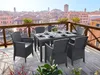 An outdoor dining set on a balcony overlooking a city with canals. Produktbild-Vorschau