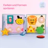 An open felt book with various shapes and animal figures for sorting colors and shapes, placed on a light blue surface with a pink background. Produktbild-Vorschau