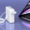 A white USB-C power adapter and cable are shown next to a laptop. Podgląd zdjęcia produktu