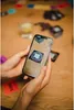 A person is holding a smartphone that is scanning a QR code on a table. Produktbild-Vorschau