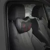 A massage pillow is attached to the headrest of a car seat. Produktbild-Vorschau