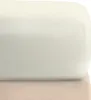 A close-up view of a cream-colored fitted sheet folded over a beige fabric base. Produktbild-Vorschau