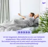 A woman is stretching in bed with a duvet. Produktbild-Vorschau