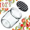 A glass jar and its lid are shown surrounded by various fresh vegetables and herbs, with a logo in the top left corner. Voir les images du produit