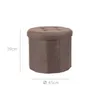 A brown ottoman stool with a tufted top and a cylindrical body, shown in isolation with dimension lines indicating its size. Podgląd zdjęcia produktu