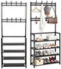 Two black metal coat racks and shoe shelves are shown side-by-side against a white background. The rack on the right is accessorized with a hat, scarf, and bag. Produktbild-Vorschau