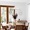 A dining area with a round wooden table and chairs, a pendant light, and a buffet table in the background. Produktbild-Vorschau