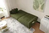 A green sofa bed is shown in a room with a rug and a small table. Produktbild-Vorschau