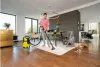 A woman is vacuuming a rug in a modern living room with a Kärcher wet and dry vacuum cleaner. Náhled obrázku produktu