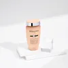 A bottle of Kerastase Curl Manifesto Gentle Hydrating Creamy-Shampoo is displayed on a white platform with geometric shapes. Produktbild-Vorschau