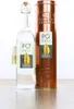 A bottle of grappa and its copper-colored gift tin are displayed on a wooden surface against a white background. Produktbild-Vorschau