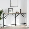 A console table with a wooden top and black metal legs, decorated with a framed picture and a vase. Náhled obrázku produktu