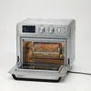 An open air fryer oven with a rotisserie basket filled with french fries. Podgląd zdjęcia produktu