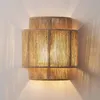 A wall-mounted light fixture made of jute rope, attached to a white wall. Voir les images du produit