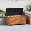 An outdoor storage box with its lid open, showing cushions inside, placed on a patio next to a chair. Produktbild-Vorschau