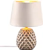A table lamp with a textured ceramic base and a fabric lampshade. Anteprima dell’immagine prodotto