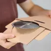 A person is holding a circular saw blade in cardboard packaging. Produktbild-Vorschau