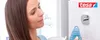 A woman is looking at a tesa hook on a wall, and a hand is holding a blue towel to hang on it. Anteprima dell’immagine prodotto