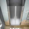 A shower enclosure with frosted glass doors and silver handles, set against a decorative wall with a beach theme. Produktbild-Vorschau