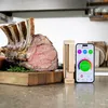 A cooked roast beef with a meat thermometer and a smartphone displaying the temperature readings. Náhled obrázku produktu