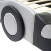 A close-up view of a bed frame designed to look like a car, focusing on the wheel and side panel. Produktbild-Vorschau