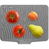 A gray silicone drying mat with water droplets and several fruits (tomatoes, an apricot, and a pear) on it. Produktbild-Vorschau