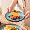 Eine Person wird den Dessertteller mit dem Dessert auf den Tisch stellen. Náhled obrázku produktu