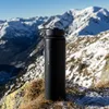 A black thermos bottle is placed on a rock in a snowy mountain landscape. Produktbild-Vorschau