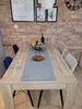 A dining table set with a festive centerpiece and place settings, in front of a brick wall. Produktbild-Vorschau