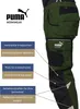 A close-up side view of green work pants with black accents, highlighting features with text callouts. Produktbild-Vorschau