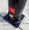 Close-up of the base of a black outdoor shower with a metal hose connection and a red label. Produktbild-Vorschau