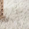 A close-up view of a fluffy white rug with a woven basket edge. Produktbild-Vorschau
