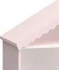 A close-up view of the top corner of a pink and white shelf unit designed to look like a house. Náhľad obrázku produktu