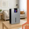 A silver dehumidifier is placed on a wooden table in a living room. Anteprima dell’immagine prodotto