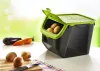 A kitchen storage container for potatoes and onions is shown on a white surface with some vegetables in the foreground and background. Produktbild-Vorschau