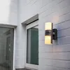 An outdoor wall light mounted on a brick wall next to a window. Anteprima dell’immagine prodotto