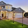 A modern house with a driveway and lawn, illuminated by solar-powered lampposts. Produktbild-Vorschau