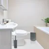 A clean and modern bathroom setting with a sink, toilet, and bathtub. Anteprima dell’immagine prodotto