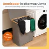 A laundry basket filled with clothes next to a washing machine. Produktbild-Vorschau