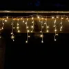 Icicle lights hanging from a wooden overhang at night. Produktbild-Vorschau