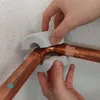 Hands are shown using a tool to protect copper pipes during installation. Produktbild-Vorschau
