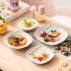 A table setting with multiple plates of food, drinks, and condiments, suggesting a meal or dining experience. Náhled obrázku produktu