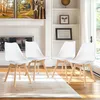 Four white dining chairs with wooden legs are arranged on a rug in a well-lit room with bookshelves in the background. Voir les images du produit