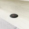 A close-up view of a black circular power outlet embedded in a light-colored wooden surface. Produktbild-Vorschau