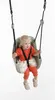 A young child is sitting in a green baby swing. Podgląd zdjęcia produktu