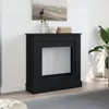 A black fireplace surround is shown in a room with a painting above it and a plant to the side. Náhled obrázku produktu