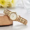 A gold Citizen women's solar watch with a white face rests on a wooden surface, with blurred yellow flowers in the background. Anteprima dell’immagine prodotto